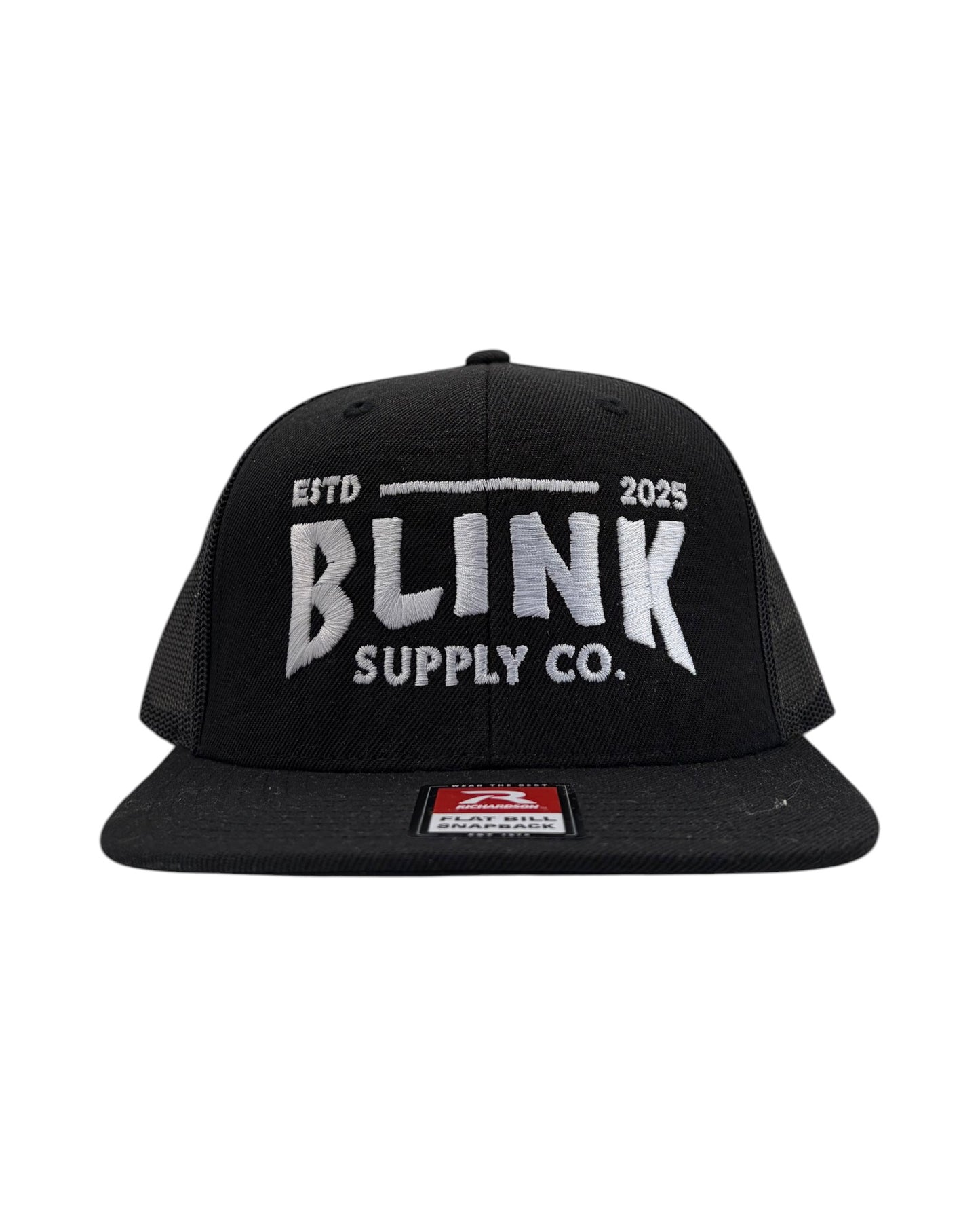 Blink Supply Co. black trucker hat with embroidered logo and flat bill. Features a snapback closure and mesh back panels.