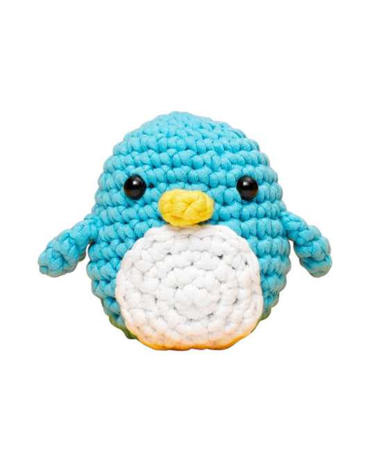 Blink Supply Co Pierre the Penguin beginner crochet kit. Blue, white, and yellow yarn with black safety eyes.