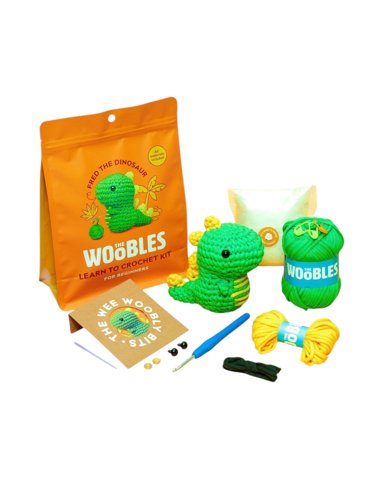 Blink Supply Co Fred the Dinosaur crochet kit for beginners. Includes green yarn, yellow yarn, crochet hook, stuffing, and eyes.